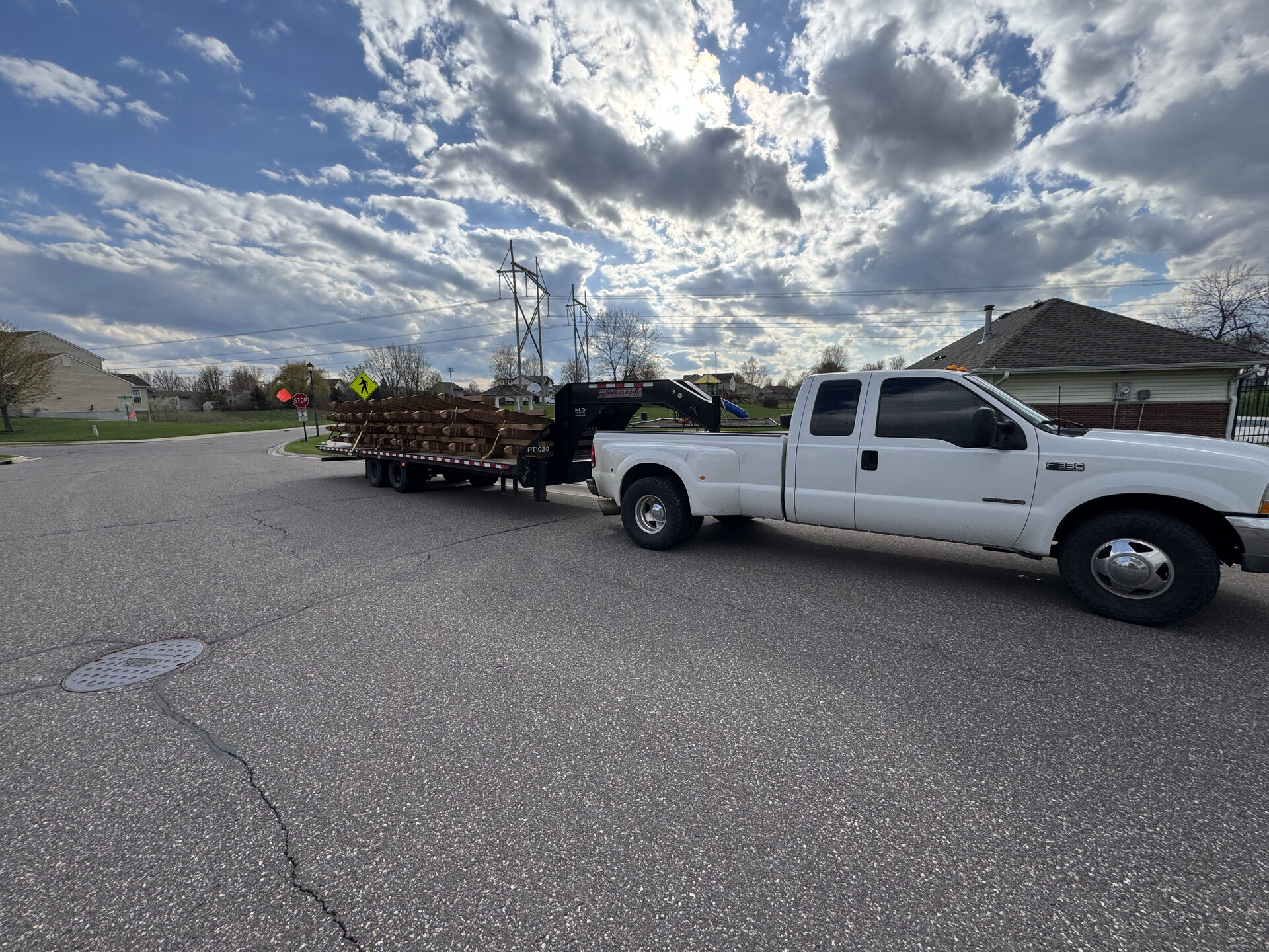 CDI Service Now truck hauling a loaded gooseneck flatbed trailer