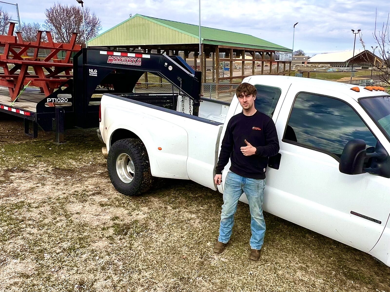 Cole Isaacs, owner of CDI Service Now, beside his truck and trailer